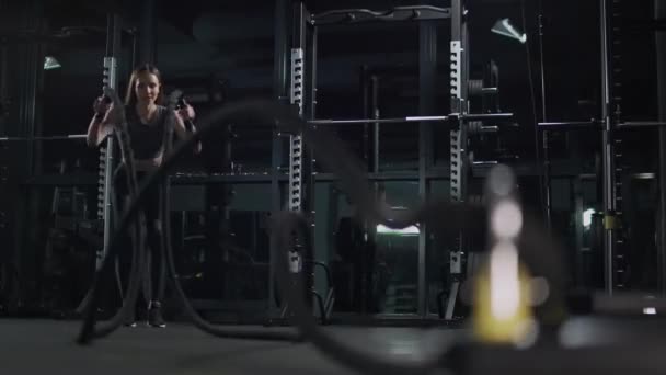 Здоровий спосіб життя, жінка виконує вправи з бойовими мотузками, тренування витривалості в тренажерному залі, повільний рух 4k . — стокове відео