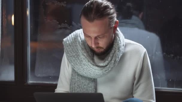 Hombre freelancer está sentado en el suelo y trabajando en un ordenador portátil, los tipos de texto en el teclado, la hora de la noche, el trabajo remoto de la casa de campo, la hora de invierno. — Vídeos de Stock