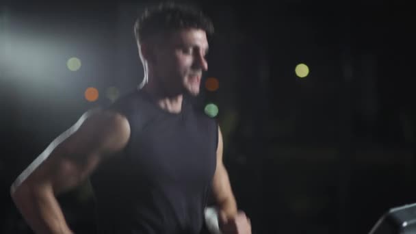 Cinematic light, anonym man kör på löpband, aerob träning och uthållighetsträning i gymmet. — Stockvideo