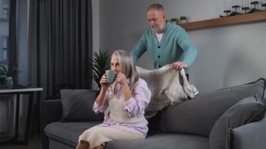 Yaşlı, gri saçlı bir adam karısına battaniye örterek, sevdiklerine bakar, yetişkin insanlar evde rahatça dinlenir, yaşlı bir kadın televizyon izler ve kakao içer.