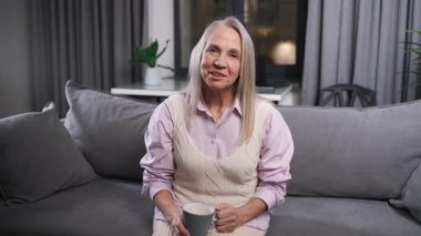 Yaşlı kadın evdeki kanepede oturur ve video yoluyla akrabalarıyla iletişim kurar, kendini izole eden büyükannesi, salgın hastalık bağlamında uzaktan iletişim kurar, ekran için şablon oluşturur..