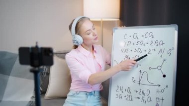 Kadın kimya öğretmeni internetten bir ders veriyor, akıllı telefon, okul dersleri ve koronavirüs salgını bağlamında uzaktan çalışma kullanarak öğrenciler için öğrenme sürecinin canlı yayını.