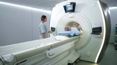 Modern hastanede manyetik rezonans görüntüleme, genç kadın doktor yaşlı bir adam, MRI, modern tıp teknolojileri üzerinde manyetik tomografi incelemesi yapıyor..