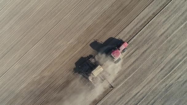 Campagna e agricoltura, trattori agricoli arare la terra in campo, polvere nel campo, vista dall'alto, semina di grano. — Video Stock