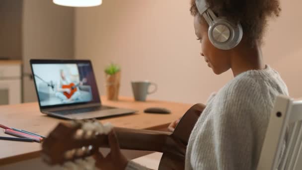 Musikunterricht, junge Afrikanerin spielt Gitarre mit einem Lehrer per Videoanruf, Fernunterricht über Selbstisolierung, Kommunikation unter Quarantäne, das Coronavirus — Stockvideo