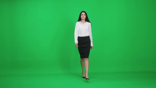 スーツ姿の女性が緑の背景を歩いていると、実業家の女性が近づいてきて、カメラを見て、笑顔の女性、クロマキーテンプレート. — ストック動画