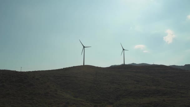 Fazenda eólica em áreas montanhosas perto das montanhas, lâminas rotativas, fontes alternativas de energia renovável, vista de turbinas eólicas. — Vídeo de Stock