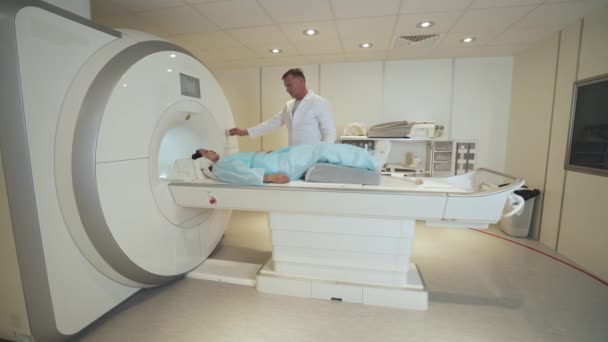 Ressonância magnética, médico profissional adulto realiza um exame tomográfico magnético de uma jovem mulher asiática, MRI, tecnologias modernas em medicina, fim do procedimento. — Vídeo de Stock
