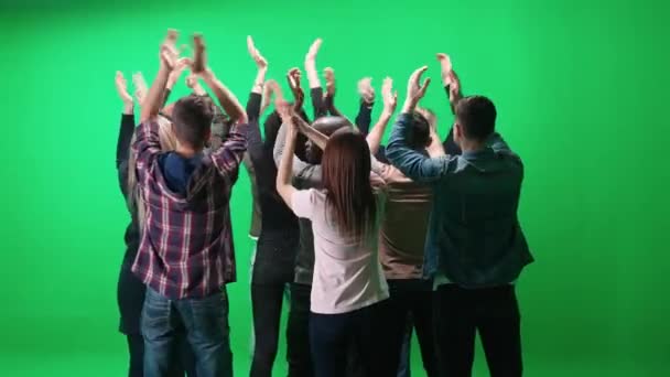 Multitud de personas de diferentes edades bailando en un concierto, retrospectiva, fans en un concierto de música, bailan y balancean sus brazos sobre un fondo verde, una plantilla de cromakey. — Vídeo de stock