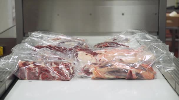 Produção de carne, o processo de embalagem de produtos à base de carne de bovino em embalagens plásticas, embalagem térmica de produtos alimentares acabados. — Vídeo de Stock