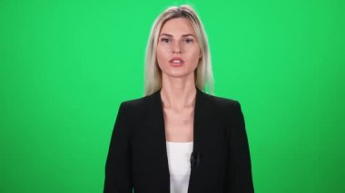 Takım elbiseli kadın muhabir kameraya bakar ve konuşur, yeşil arka planda bir kadın, TV haber ajansları için şablon, iş yerinde gazeteci, kromakey.