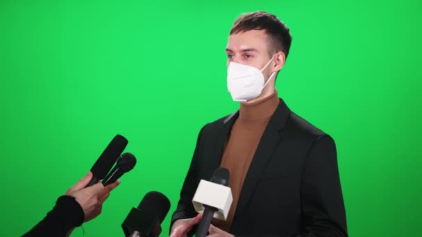 Fehér férfi orvosi maszkban interjút ad újságíróknak, kommunikáció a koronavírus világjárvány idején, chromakey sablon. — Stock videók