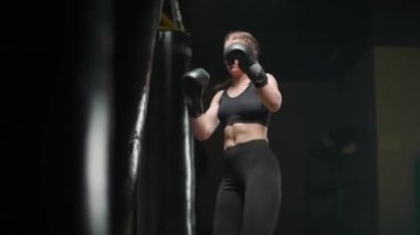 Kickboks, agresif kadın boksör yumruklarını geliştirir, kum torbasını döver, boks salonunda antrenman yapar, formda bir vücut..