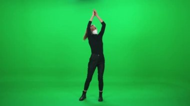 Konserde dans eden kadın, müzik konserinde koruyucu tıbbi maske takan kadın, dans eden ve ellerini yeşil arka planda çırpan kadın, kromakey şablonu, Coronavirus salgını sırasında olan olay..