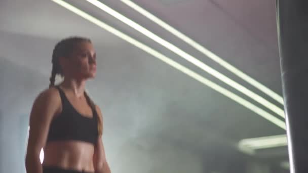 여자 선수가 권투 체육관에서 훈련을 받기 전에 몸에 힘을 주고 몸에 힘을 준다. — 비디오