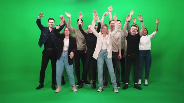 Crowd of people of different ages dancing at a concert, fans at a music concert, they dance and swing their arms on a green background, a chromakey template. — Stock Video