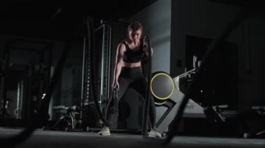 Kafkas atletik kadın savaş halatlarıyla tatbikatlar yapıyor, spor salonunda dayanıklılık eğitimi alıyor, 4k ağır çekim..