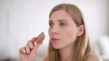 Kafkasyalı genç bir kadının portresi mutfakta oturuyor ve makarna, tatlı tatlılar ve şeker tüketimi yiyor..