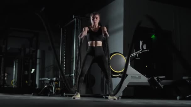 Peleadora caucásica realiza ejercicios con cuerdas de batalla, entrenamiento de resistencia en el gimnasio, 4k cámara lenta. — Vídeos de Stock