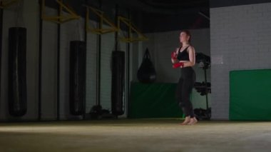 Boks salonunda koordinasyon eğitimi, beyaz kadın boksör ipe atlıyor..