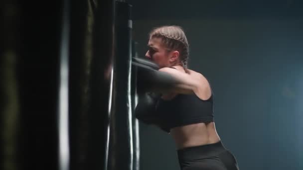 Atletica combattente femminile allena i pugni, batte un sacco da boxe, giornata di allenamento di kickboxing in palestra, 4k rallentatore. — Video Stock