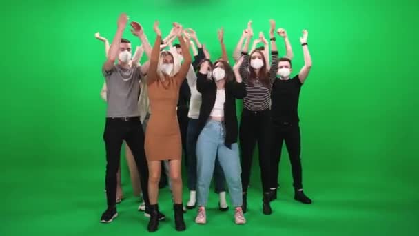 Crowd of different people dancing at a concert, fans at a music concert, they dance and clap their hands on a green background, a chromakey template. — Stock Video