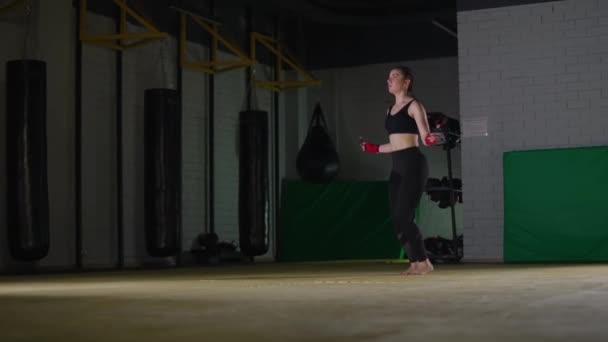 Entrenamiento de coordinación en el gimnasio de boxeo, luchadora caucásica salta en una cuerda, cuerpo en forma de fuerza. — Vídeos de Stock