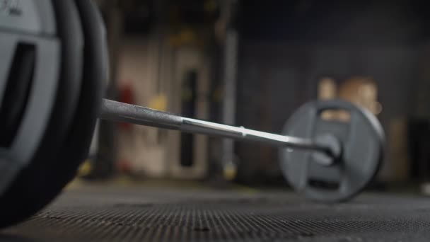 Homem atlético anônimo executa um deadlift com barra, levanta barra e faz musculação treinamento no ginásio, visão de ângulo inferior. — Vídeo de Stock