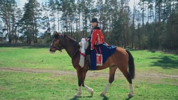 Mujer en un traje medieval brillante monta un caballo a través de un campo, reconstrucción, 4k cámara lenta. — Vídeo de stock