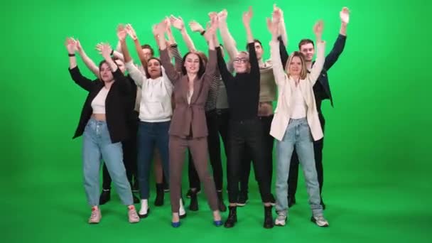 Crowd of different people dancing at a concert, fans at a music concert, they dance and swing their arms on a green background, a chromakey template. — Stock Video