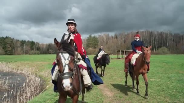 Las hembras en un traje medieval brillante paseos a caballo a través de un campo, reconstrucción, mujeres medievales montar a caballo en un claro verde, 4k cámara lenta. — Vídeo de stock