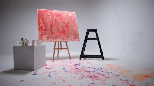 スローモーション、女性アーティストは白い部屋の大きなキャンバスにブラシで描く、才能のあるアーティストは、色の赤の抽象化を描く、油絵の現代美術. — ストック動画