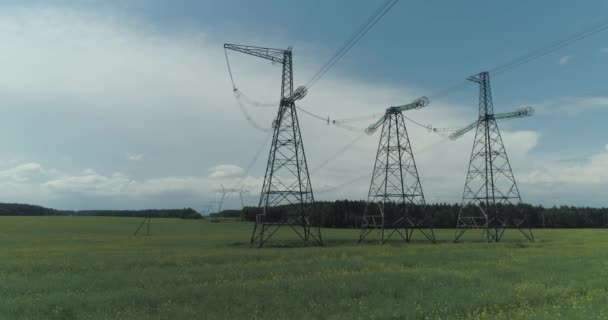 Power line, industrial view on the line of electric transmissions in field, steel towers with wires and communication of electric power supply in countryside, view from a height. — Stock Video