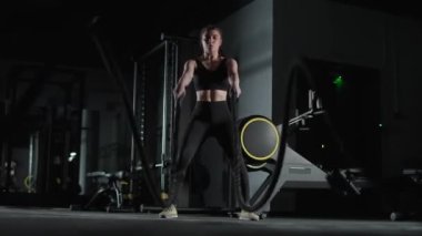 Kafkas atletik kadın dövüşçü dövüş halatları ve dayanıklılık eğitimiyle boks salonunda egzersiz yapıyor..