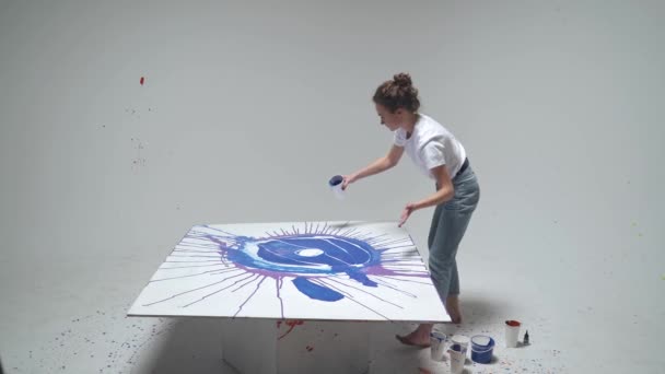 Női művész rajzol öntött festék a vászonra, egy tehetséges művész rajzol egy színes kék absztrakció, modern művészet. — Stock videók