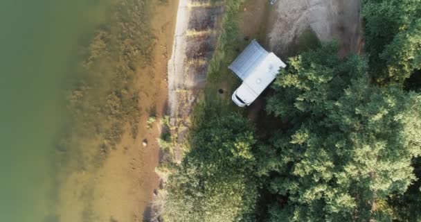 Loisirs de plein air, vue depuis la hauteur d'un mobil-home situé près d'un lac dans la forêt, repos en camping-car pendant l'auto-isolement, vue aérienne. — Video