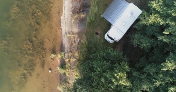 Odpoczynek na łonie natury, widok z wysokości mobilnego domu stojącego w pobliżu jeziora w lesie, wypoczynek w wagonie kempingowym podczas samoizolacji, widok z lotu ptaka. — Wideo stockowe