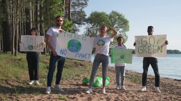 Eco-attivisti con manifesti in mano protestano contro l'inquinamento della natura, un incontro di volontari di diverse razze ed età, la gente tiene un poster con chiamate per salvare la natura, senza plastica, 4k — Video Stock