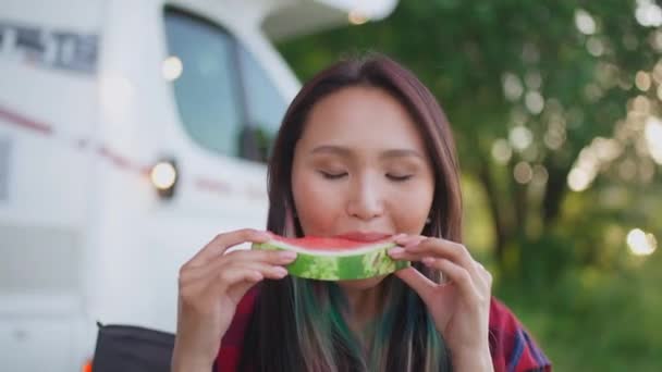 Retrato ao ar livre de uma mulher asiática na natureza, uma jovem mulher comendo uma melancia e desfrutando de comida de frutas, verão, piquenique na natureza. — Vídeo de Stock