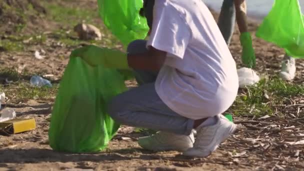 HANDHELD, eco-activistas limpian basura en el bosque, luchan contra la contaminación plástica de la naturaleza, personas de diferentes razas y edades limpian basura en el bosque, cuidan de la naturaleza. — Vídeos de Stock