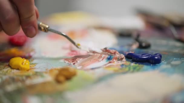 手持式，男性艺术家用调色刀搅拌油画，工作中的创意人物，特写. — 图库视频影像