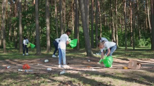 Eco-activists and volunteers clean up garbage in the forest, fight against plastic pollution of nature, people of different races and ages clean up garbage in forest, take care of nature, 4k slow — Stock Video