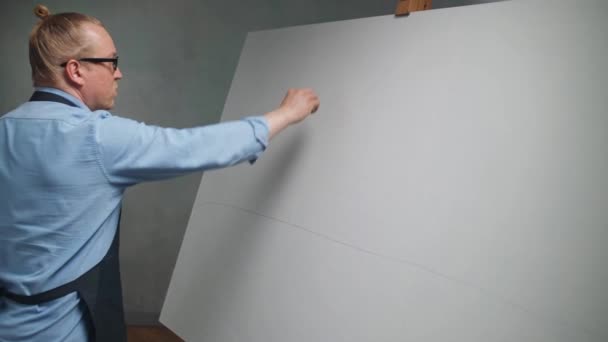 Art studio, kreativní dospělý muž v práci, talentovaný muž umělec kreslí kresby na plátno tužkou, kreslí čáry, zpomaluje 4k. — Stock video