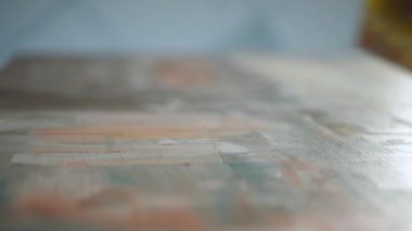 Yavaş çekim, yaratıcı kişi, yetenekli bir sanatçı tuvali gri-bej boya ile kaplar, astar ve çizer, ellerin yakın görüntüsü.