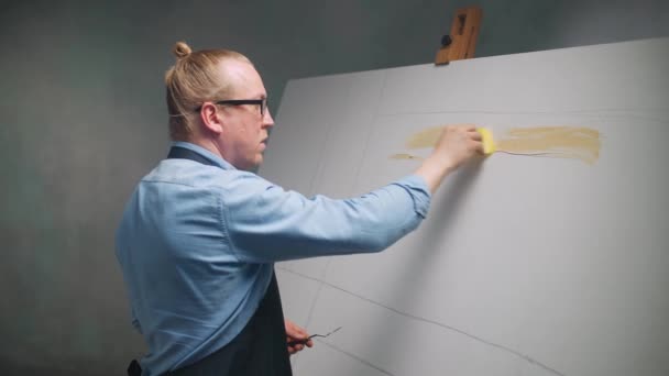 En cámara lenta, persona creativa en el trabajo, un talentoso artista masculino dibuja un cuadro abstracto en un lienzo grande. — Vídeos de Stock