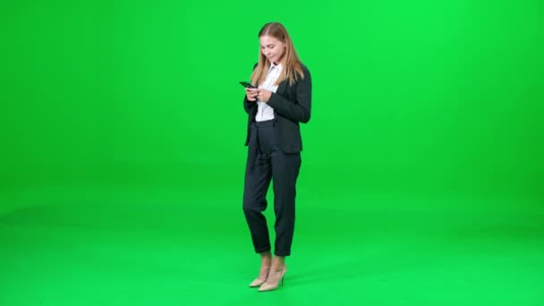 Női üzletasszony öltönyben áll a chroma kulcs háttér, nő beszél a mobiltelefon, zöld háttér, chromakey sablon. — Stock videók