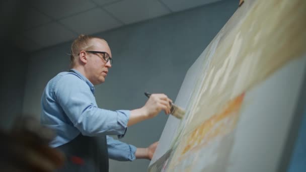 Kreative Person bei der Arbeit, ein talentierter erwachsener Mann Künstler bedeckt die Leinwand mit beiger Ölfarbe, zeichnet das moderne abstrakte Bild, 4k Zeitlupe. — Stockvideo