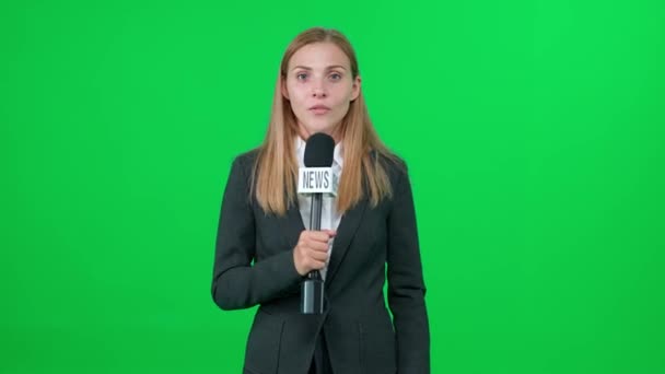 Noticias de última hora, reportera de noticias caucásica habla en un micrófono sobre un fondo verde y mira a la cámara, plantilla para agencias de noticias de televisión, periodista en el trabajo, chromakey. — Vídeo de stock