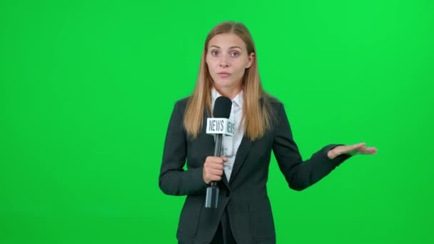 Ultime notizie, giornalista caucasica femminile parla in un microfono su sfondo verde e guarda nella fotocamera, modello per le agenzie di stampa TV, giornalista donna al lavoro, chromakey. — Video Stock