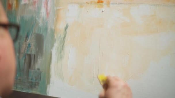 Творча людина на роботі, талановитий дорослий чоловік художник охоплює полотно олійною фарбою, малює сучасну абстрактну картину, майстерню художників . — стокове відео